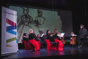 orkiestra smyczkowa a w tle animacja piaskiem